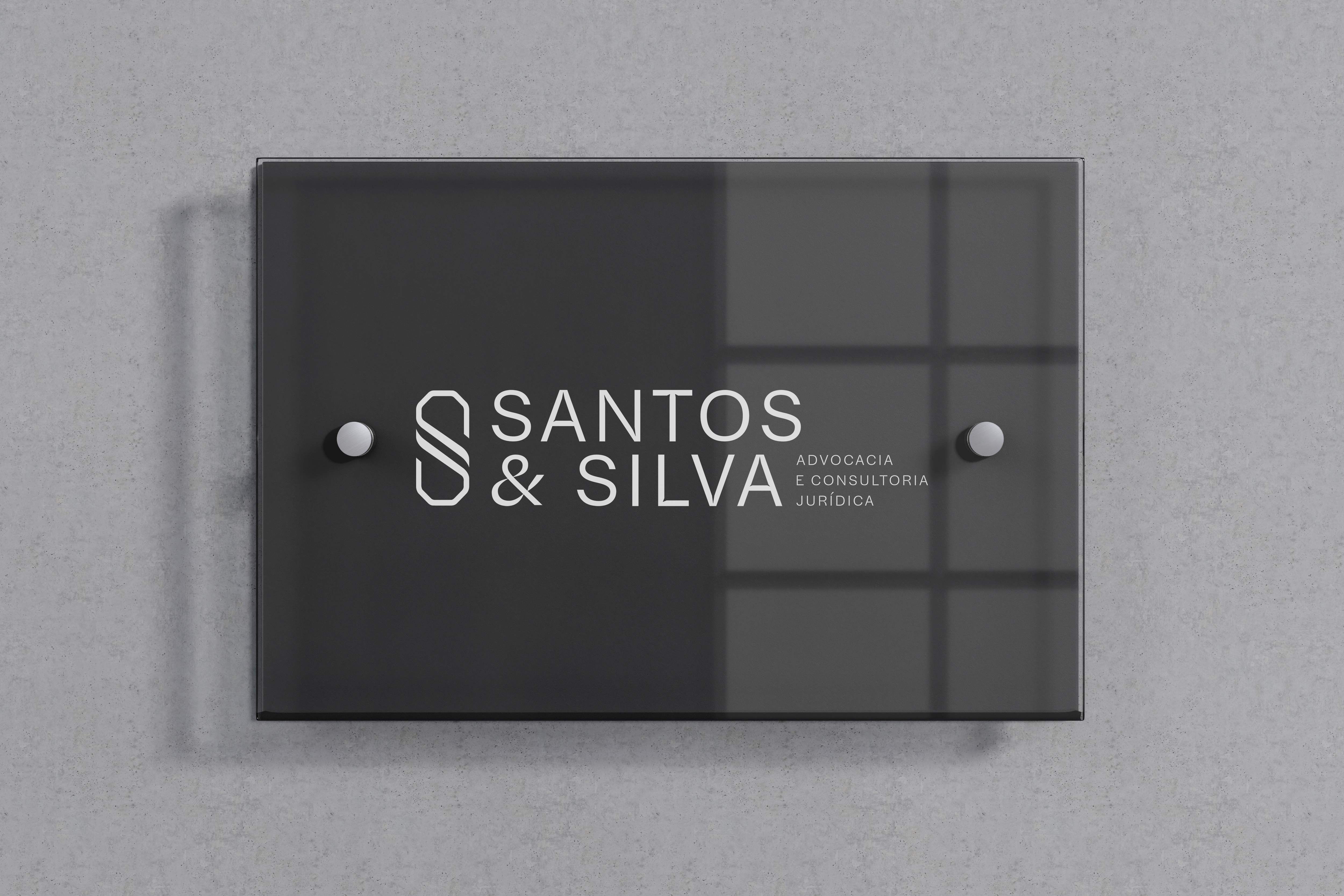 Placa de vidro com o logo Santos & Silva na recepção do escritório, em Cuiabá
